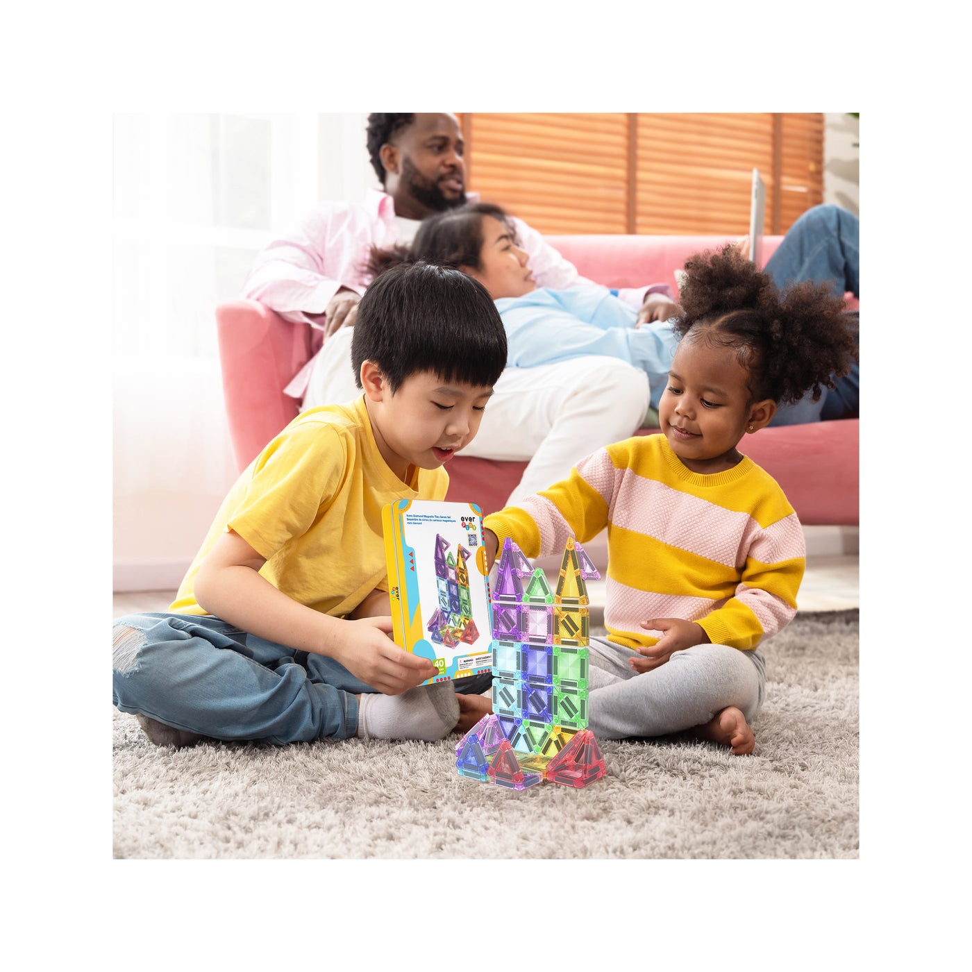 Children building a colorful castle with the EverPlay 50-piece magnetic tile set while adults relax in the background.
