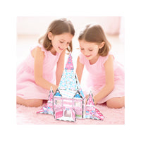 Two girls in pink dresses building a PicassoTiles Hello Kitty magnetic toy castle on a pink rug.