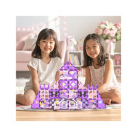 Two girls smiling next to a large purple Kuromi magnetic tile castle built on a rug in a playroom.