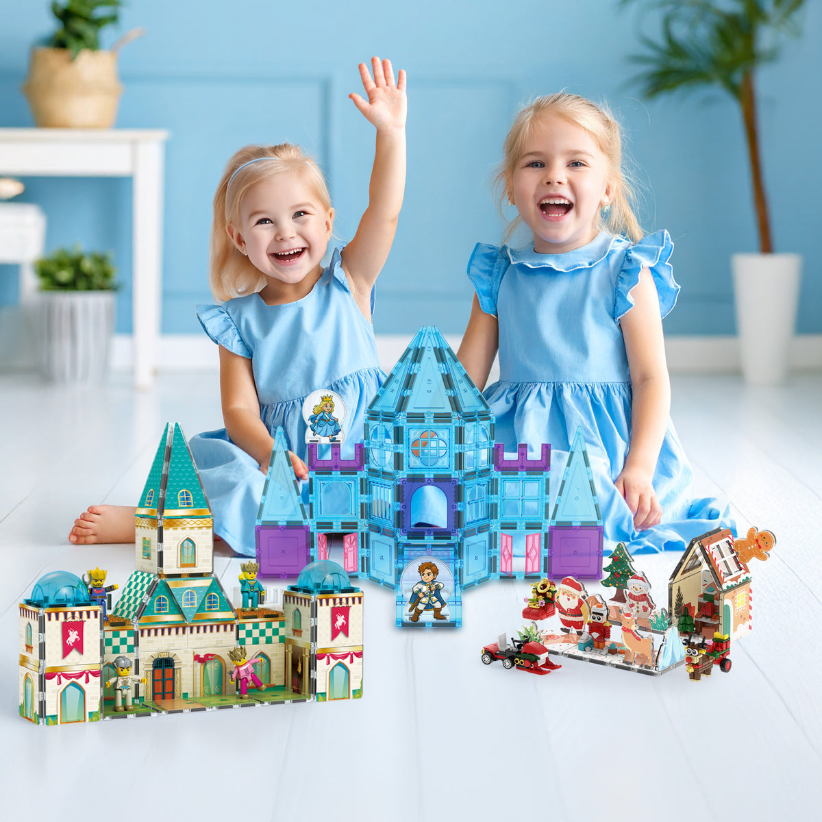 Two young girls in matching blue dresses playing with magnetic tile castle and Christmas building sets.   
