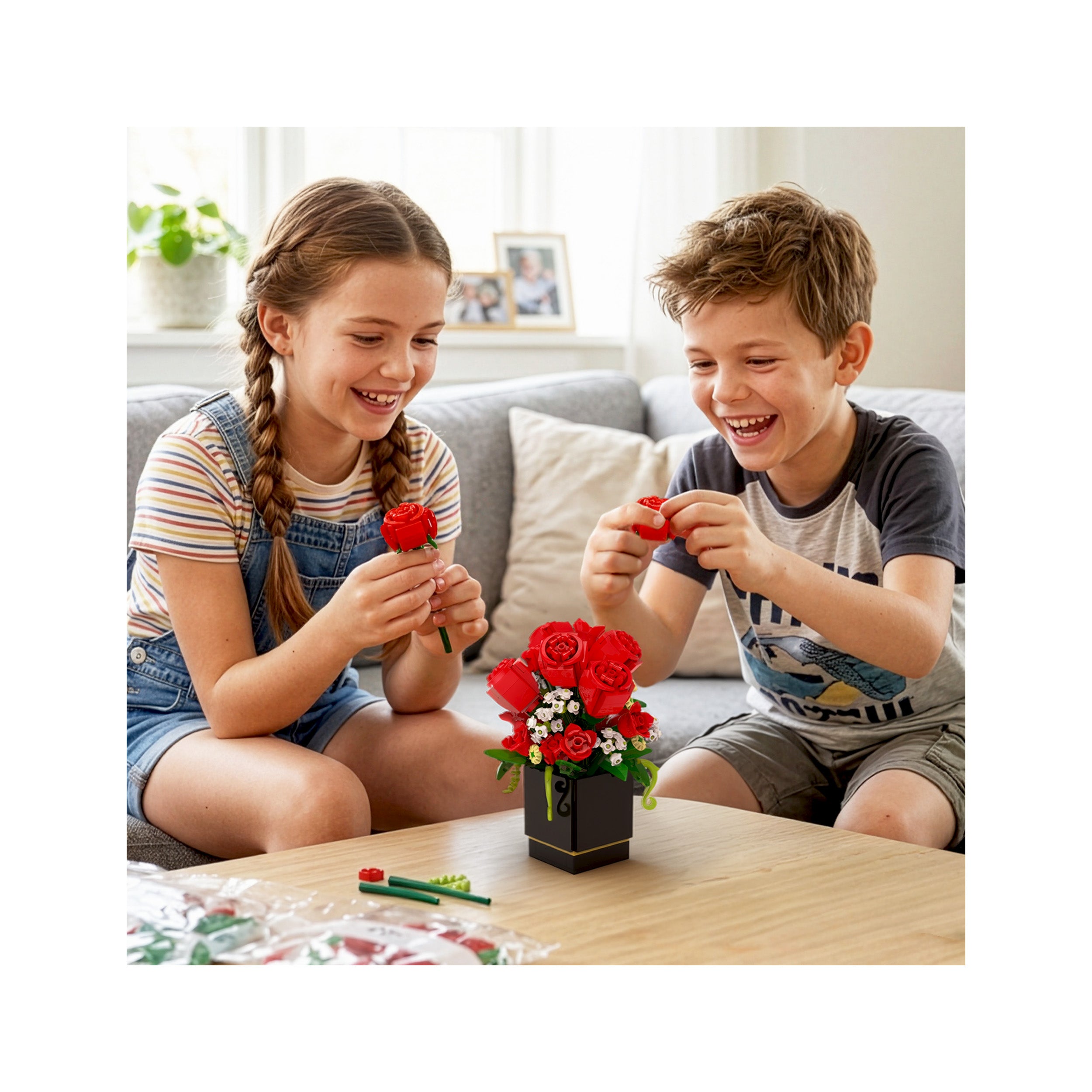 Two happy children assembling a colorful building-block flower bouquet in a vase on a coffee table.