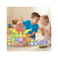 Two children happily building a large colorful magnetic tile castle and rolling a magnetic toy car on the floor.