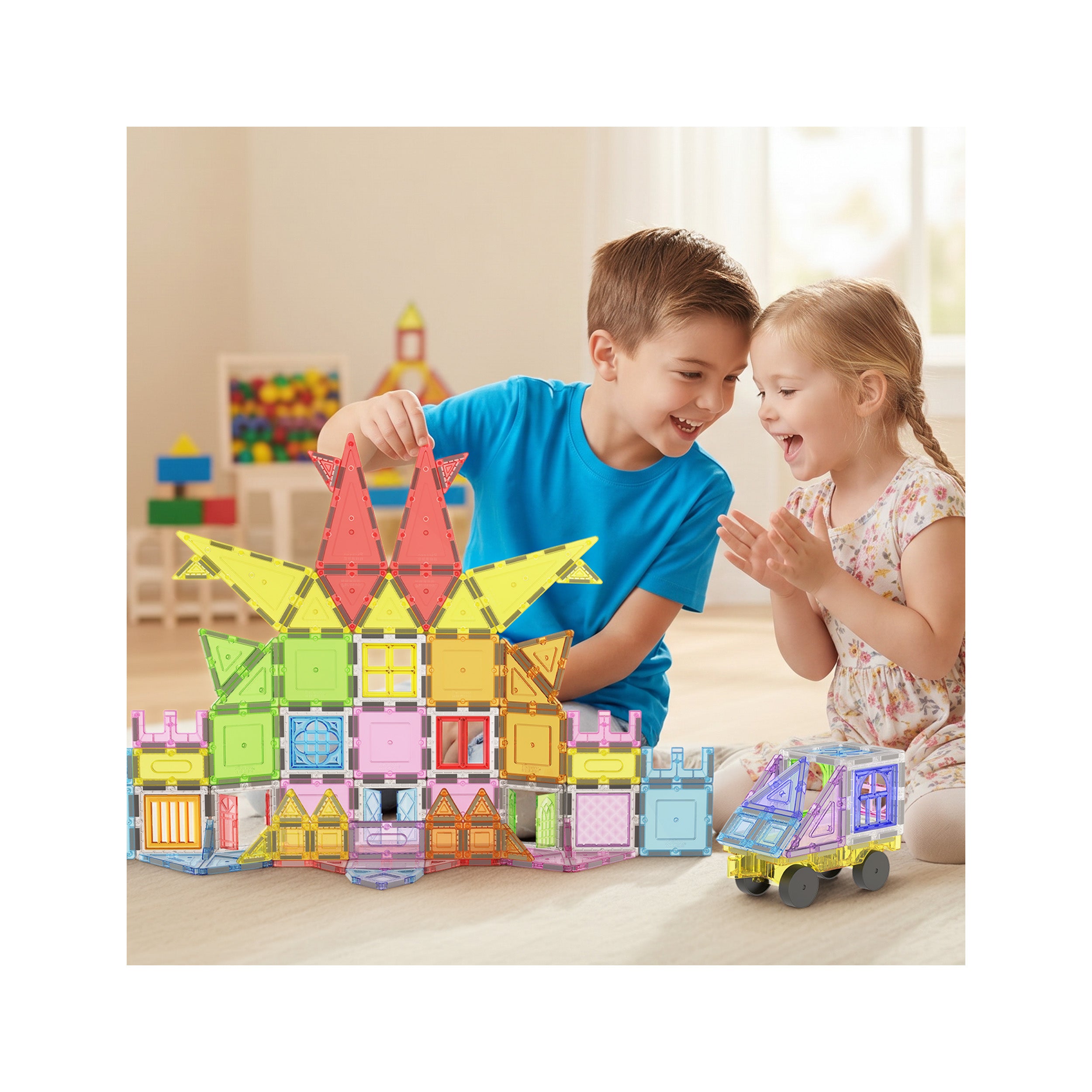 Two children happily building a large colorful magnetic tile castle and rolling a magnetic toy car on the floor.