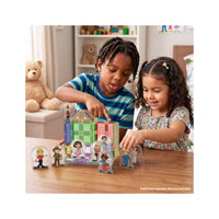 Two kids playing with magnetic tile structures and cartoon character figure standees at a wooden table.