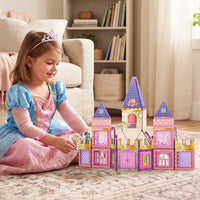Girl dressed up as a princess playing with s pink and purple princess castle toy set
