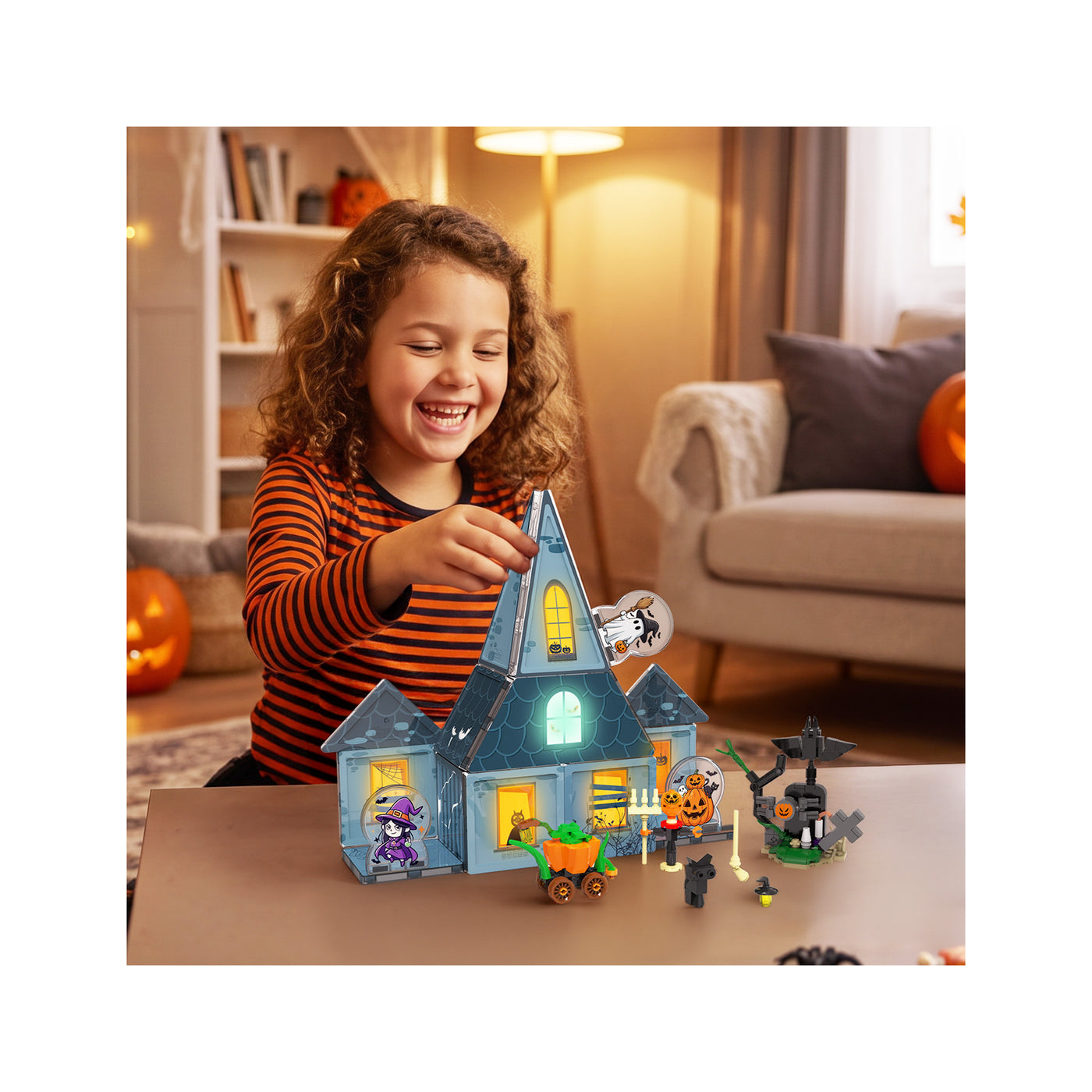 Young girl playing with a Halloween magnetic haunted house set on a table.