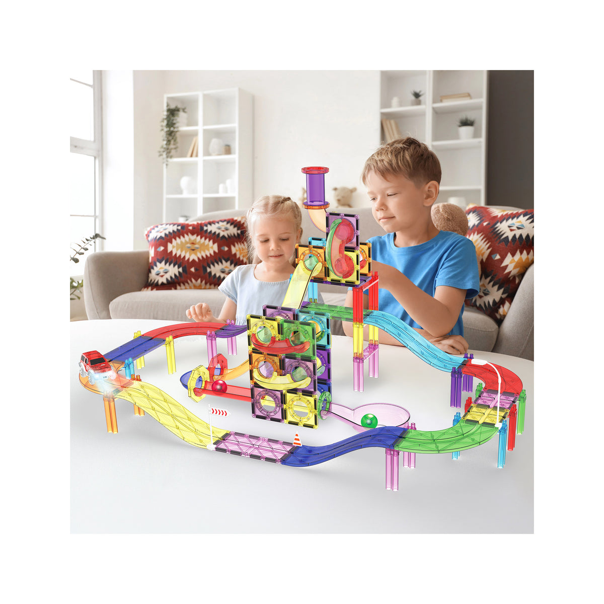 Two children playing indoors with a PicassoTiles magnetic marble run and race track playset with LED toy car.   